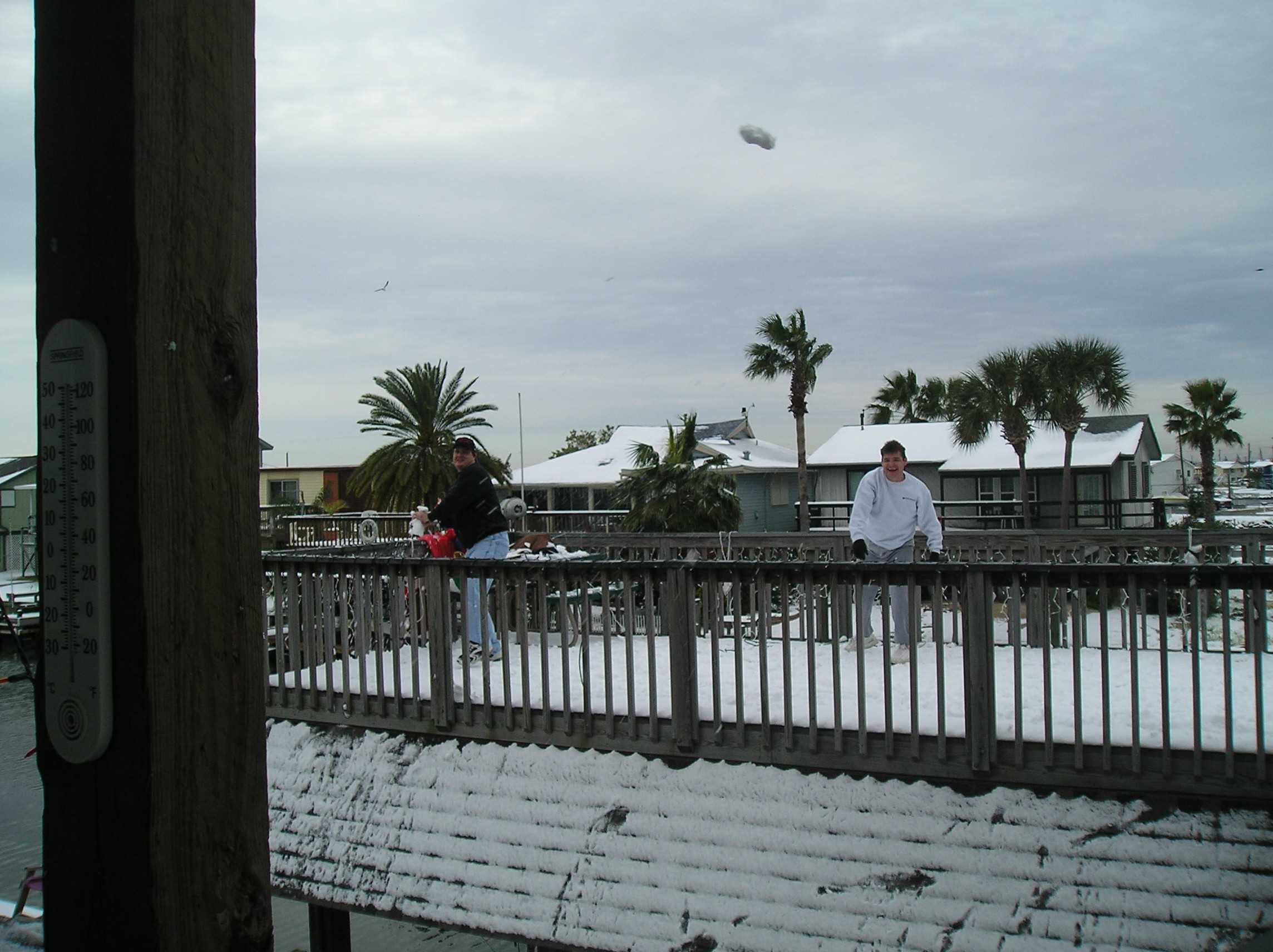 Connie Young's son Rob from Pearland is having a snowball fight with Don Clayton. Don is the Young's son-in-law, who was visiting from Florida.